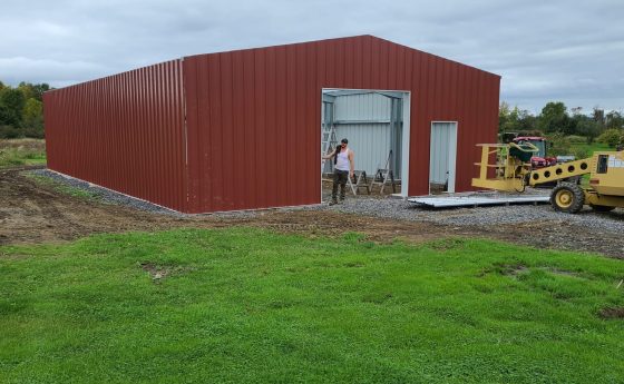 Red Steel Building Getting Built with Small Crane