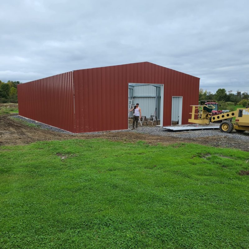 Red Steel Building Getting Built with Small Crane