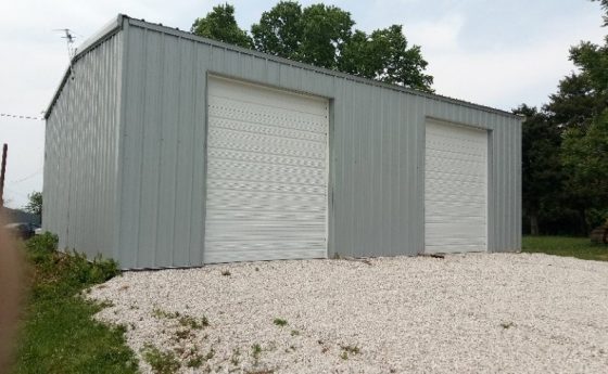 Gray Steel Garage with White Roll Up Doors