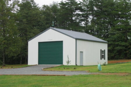 Detached White Steel Garage with Green Roll-Up Door